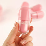 a hand holding a pink tinted aggi beauty lipgloss